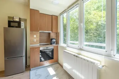 a kitchen with a refrigerator and some windows at Top Location, Brand New 3 BDRM Apt & Free parking in Sofia