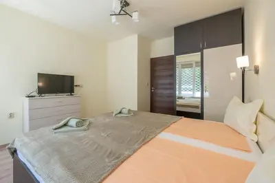 a bedroom with a large bed with a flat screen tv at Top Location, Brand New 3 BDRM Apt & Free parking in Sofia