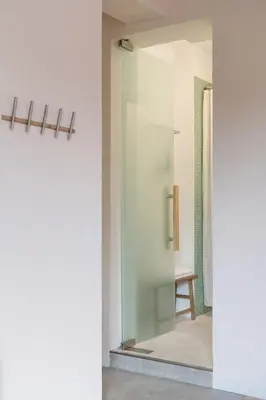 a glass door leading to a shower in a bathroom at Dazzling Minimalist One Bedroom Apartment in Sofia
