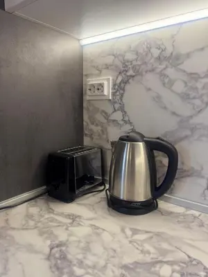 a tea kettle and a toaster on a counter at West Park Apartment in Sofia
