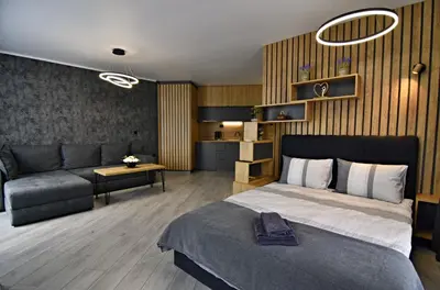 a bedroom with a large bed and a couch at Апартамент Жери in Velingrad