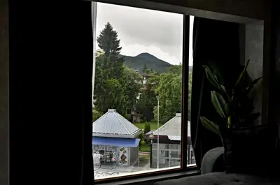 a window with a view of a building and a mountain at Апартамент Жери in Velingrad
