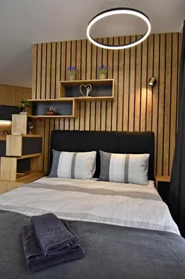a bedroom with a large bed with a black headboard at Апартамент Жери in Velingrad