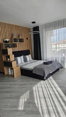 a bedroom with a large bed and a large window at Апартамент Жери in Velingrad