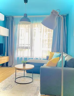 a blue living room with a couch and a table at Luxurious apartment 1BDR by Top Kvartiri Ltd in Sofia
