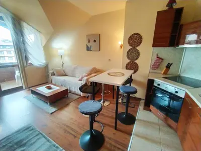a small kitchen and living room with a table and chairs at Cozy flat in NEON in Bansko