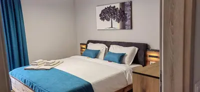 a bedroom with a large bed with blue pillows at Apartmenthaus Oborishte - 31 in Panagyurishte