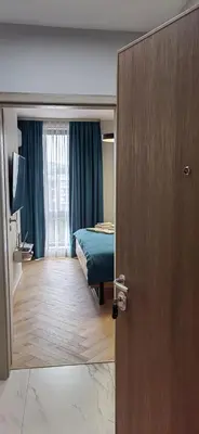 a bedroom with a bed and a door with a mirror at Apartmenthaus Oborishte - 31 in Panagyurishte