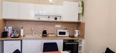 a kitchen with white cabinets and a counter top at Apartmenthaus Oborishte - 31 in Panagyurishte