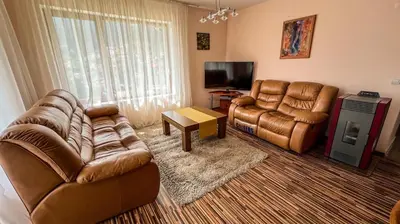 a living room with two leather chairs and a television at Villa Orpheus in Chepelare