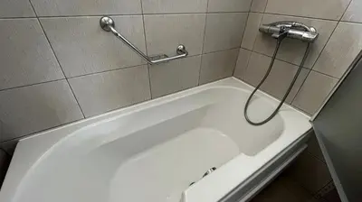 a white bath tub with a hose attached to a wall at Villa Orpheus in Chepelare