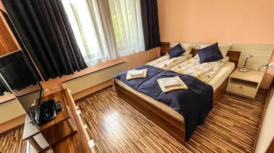 a bedroom with a bed with blue sheets and pillows at Villa Orpheus in Chepelare