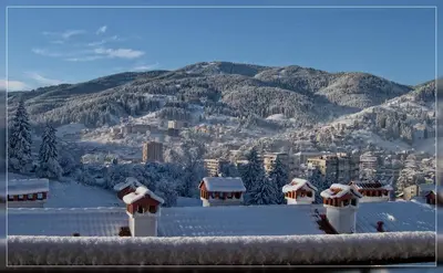 a view of a city with snow covered roofs at Villa Orpheus in Chepelare