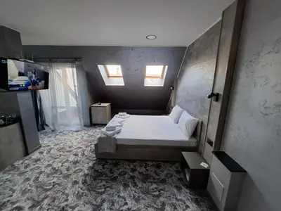 a bedroom with a bed and two windows at RCR Einstein studios 2 in Sofia