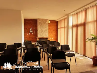 a room with chairs and a table and a podium at Chamkoria Chalets 409 in Borovets