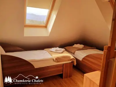two twin beds in a room with a window at Chamkoria Chalets 409 in Borovets