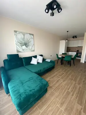 a living room with a green couch and a table at Modern 1BR Apart FREE Parking with Hill View in Plovdiv