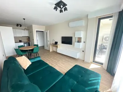 a living room with a green couch and a table at Modern 1BR Apart FREE Parking with Hill View in Plovdiv