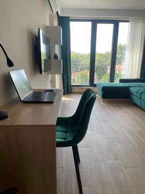 a living room with a desk with a laptop on it at Modern 1BR Apart FREE Parking with Hill View in Plovdiv