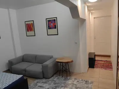 a living room with a couch and a stool at Graf Ignatiev 27 in Sofia