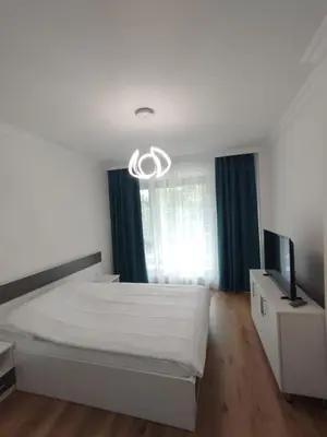 a white bedroom with a bed and a television at Stylish apartment Zingara 2 in Sofia