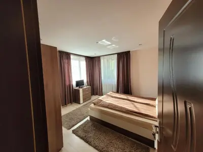 a bedroom with a bed and a television in it at Къща за гости ЕВА in Madzhare