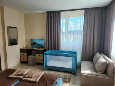 a living room with a couch and a blue table at Къща за гости ЕВА in Madzhare