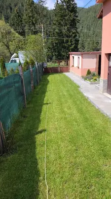 a large yard with a cord in the grass at Къща за гости ЕВА in Madzhare