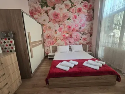 a bedroom with a bed with a floral wall at Roses in Sofia