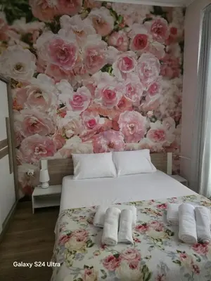 a bedroom with a wall of pink roses at Roses in Sofia