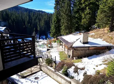 a building with snow on the ground and trees at MyPlace Pamporovo 2 in Pamporovo