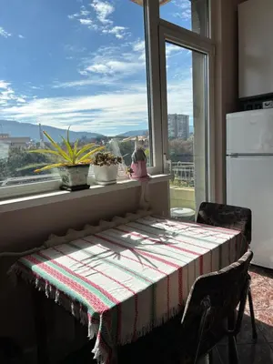 a table in a kitchen with a large window at Apartment11in the center of Sofia in Sofia