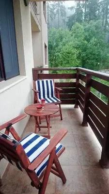 a patio with two chairs and a table on a porch at Saphir apartment , Rhodopi Pearl Pamporovo in Pamporovo