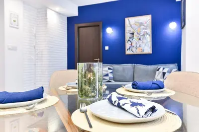 a dining room with blue walls and a table and chairs at Lyana's One Bedroom apartment in Bansko