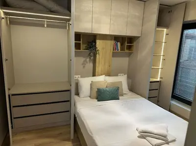 a bedroom with a white bed with a green pillow on it at Modern Vitosha Maisonette with Garage in Sofia