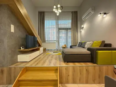 a living room with a couch and a tv at Modern Vitosha Maisonette with Garage in Sofia