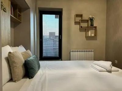 a large white bed with two pillows on it at Modern Vitosha Maisonette with Garage in Sofia