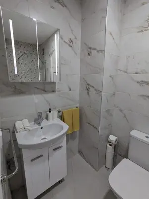 a white bathroom with a sink and a mirror at Reina Apartment- next to Sofia zoo and close to Mall Paradise in Sofia