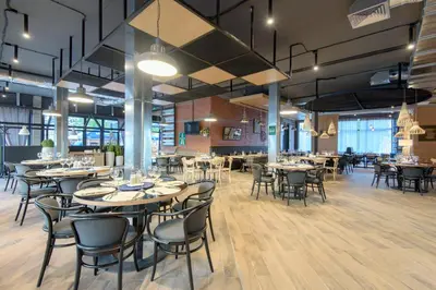 a restaurant with tables and chairs in a room at Парк Хотел Модър in Devin
