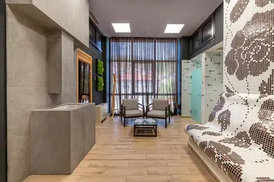 a lobby with a waiting area with chairs and a reception desk at Парк Хотел Модър in Devin