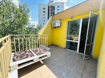 a balcony of a yellow building with a bench at Student Town 1BDR APT in Sofia