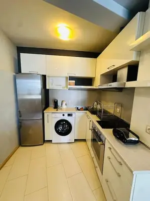 a small kitchen with a refrigerator and a stove at Student Town 1BDR APT in Sofia