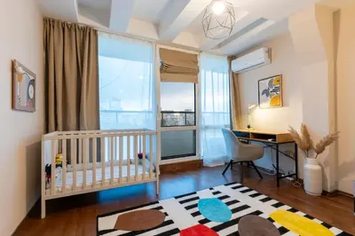 a baby room with a crib and a desk and a window at My Place in Sofia