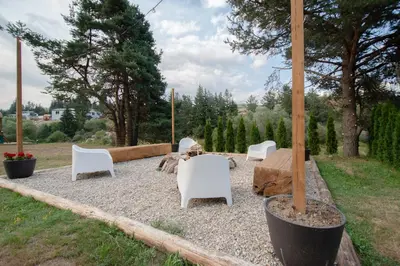 a group of white chairs and tables in a yard at Hyggemate - Nordic Villa with Sauna & Jacuzzi Retreat in Sarnitsa