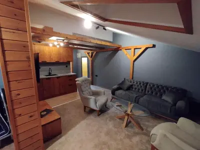 a living room with a couch and a kitchen at The Bear Pamporovo in Pamporovo