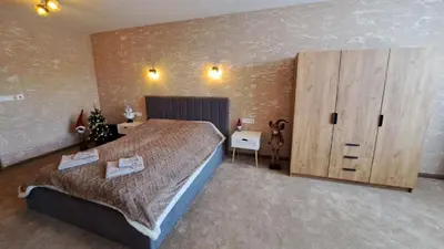 a bedroom with a large bed and a wooden cabinet at The Bear Pamporovo in Pamporovo