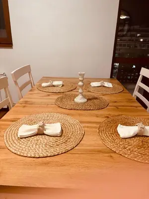 a long wooden table with several straw hats and napkins at Spacious apartment with a Mountain view, big balcony and parking in Sofia