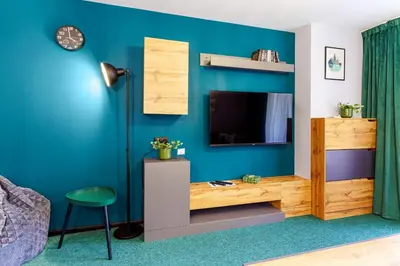 a living room with a tv and a blue wall at Mursala Pamporovo in Pamporovo