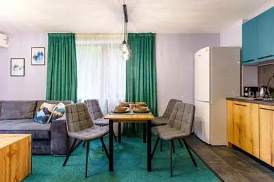 a kitchen and living room with a table and a couch at Mursala Pamporovo in Pamporovo