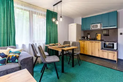 a living room with a table and a kitchen at Mursala Pamporovo in Pamporovo
